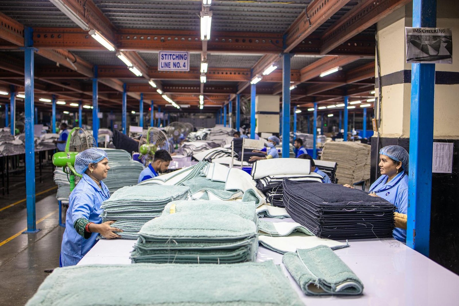 Sewing floor of a garment factory, with finished knitwear stacked at the line