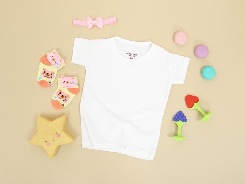 A baby T-shirt laid flat with accessories