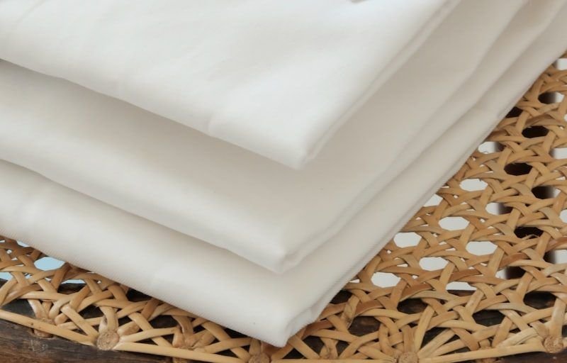 A stack of folded white cotton shirts